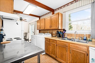 Kitchen featuring white appliances, independent washer and dryer, a ceiling fan, and plenty of natural light