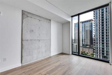 Spare room featuring floor to ceiling windows, wood finished floors, and a view of city