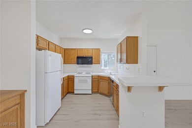Kitchen featuring white appliances, a peninsula, a