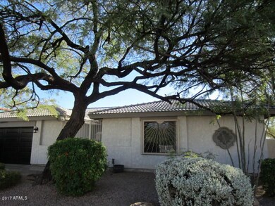 Front of home with mature landscape