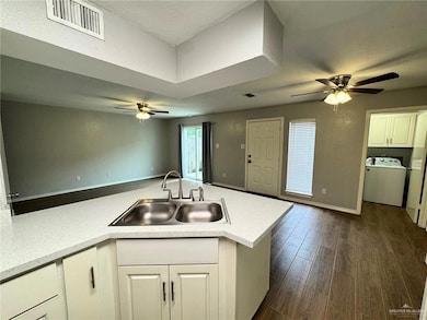 Kitchen featuring visible vents, washer / clothes dryer, a sink, and a ceiling fan