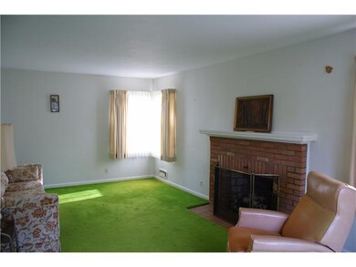 Living Room. Hardwood floors under carpet - no pets in 40 years! Woodburning fireplace and southeast corner window.