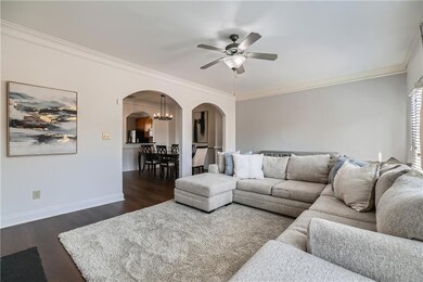 Living room with crown molding, baseboards, dark w
