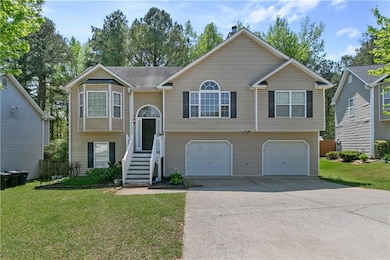 Raised ranch with an attached garage, driveway, an