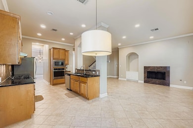 Kitchen featuring backsplash, ornamental molding, open floor plan, recessed lighting, and appliances with stainless steel finishes