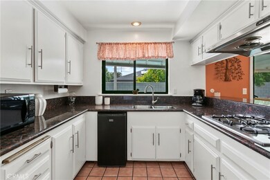 This gleaming kitchen has loads of bright white cabinetry, stone counters, stainless accents and a window at the sink with pool views...every cook's dream.