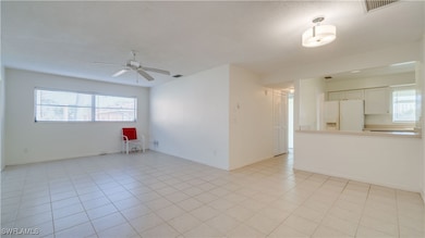 Tiled spare room featuring ceiling fan
