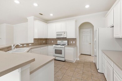 The spacious kitchen offers generous counter and storage space, walk-in pantry, gas cook top/oven combination, refrigerator and microwave.