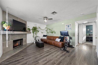 Living room featuring a ceiling fan, wood finished