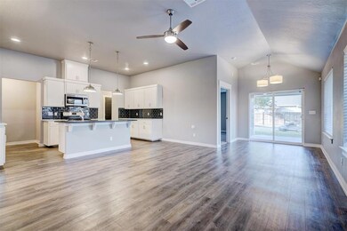 Kitchen featuring an island with sink, light hardw