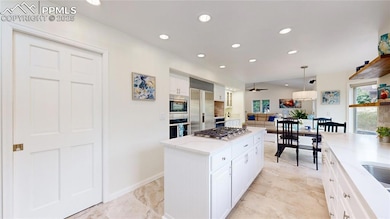 Kitchen with built in appliances, white cabinetry, recessed lighting, a center island, and pendant lighting