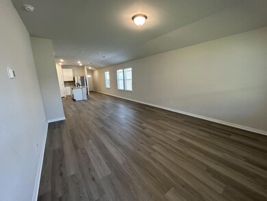 Unfurnished living room with dark wood-style floors and baseboards