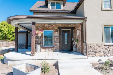 Doorway to property with stone siding, a shingled roof, and stucco siding