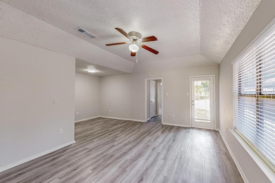 Unfurnished room featuring a textured ceiling, light wood finished floors, and ceiling fan