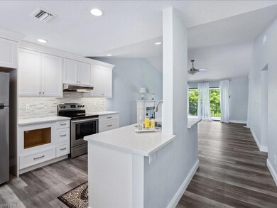 Kitchen featuring ceiling fan, dark wood-type floo
