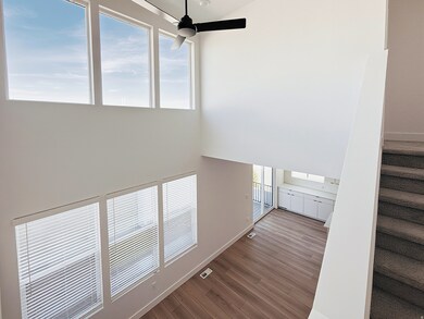 Staircase featuring wood finished floors, high vaulted ceiling, and a ceiling fan