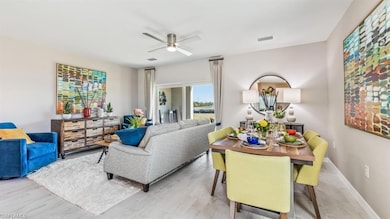 Living room with ceiling fan and light hardwood / 