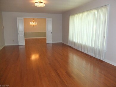 Spacious living room with hardwood floors and larg