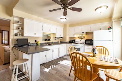 Kitchen with white cabinets, white appliances, lig