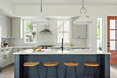 Kitchen with a sink, light countertops, backsplas