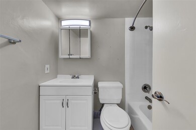 Bathroom with tub/shower combo and white vanity wi