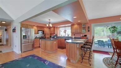 The light oak kitchen cabinetry has a island work 