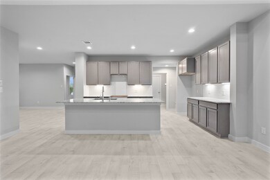 The open concept living room and kitchen makes for a great way to keep the party going and never miss a beat! Gather the family together in good conversation while preparing a fabulous meal in this breathtaking kitchen! Featuring high ceilings, light stained wood cabinets, granite countertops, SS appliances, modern tile backsplash, recessed lighting, and kitchen island with ample counter space!