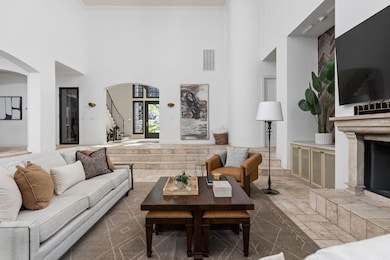 Living room featuring a towering ceiling, arched 