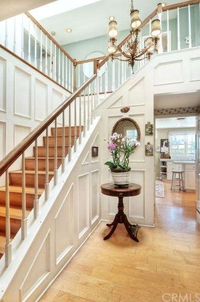 A sunny staircase in the entry leads to upstairs b