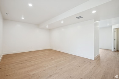 Empty room with recessed lighting and light wood-style floors