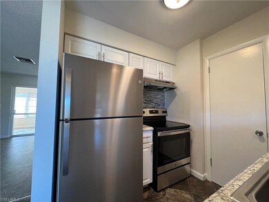 Kitchen featuring white cabinetry, stainless steel