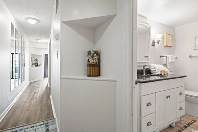 Bathroom with vanity, a textured ceiling, wood-typ