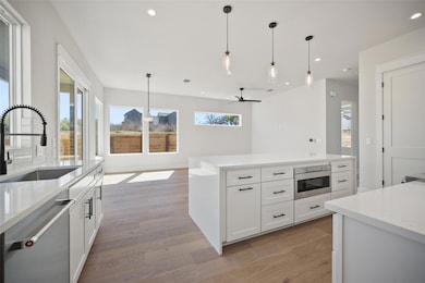 Kitchen with a ceiling fan, light wood-style floo