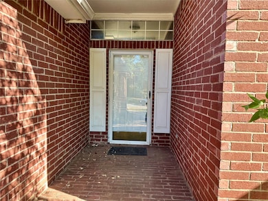 View of exterior entry with brick siding