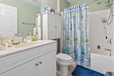 Bathroom featuring toilet, vanity, tile patterned flooring, and shower / tub combo with curtain