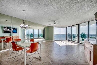 Dining area featuring a textured ceiling, a chandelier, a wall of windows, a ceiling fan, and baseboards