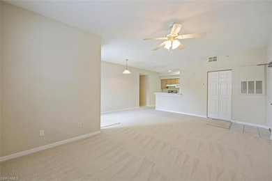 Unfurnished living room featuring light carpet and a ceiling fan