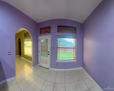 Doorway with light tile patterned floors, lofted ceiling, and a wealth of natural light