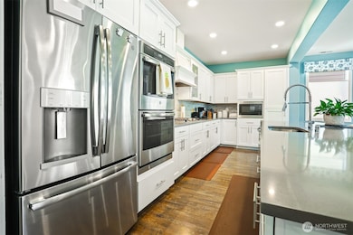 Gourmet kitchen with gas cooktop, double wall oven, french door refrigerator, stainless appliances, slab quartz countertops, center island eating bar that opens to the great room (living and dining rooms).