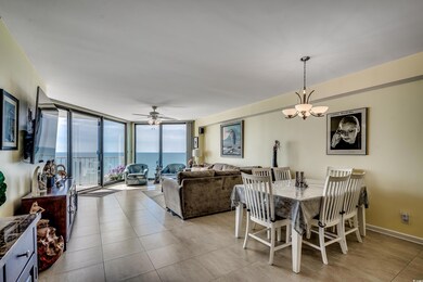Dining room featuring expansive windows, a chandelier, ceiling fan, and light tile patterned floors