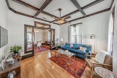 Living room featuring light wood flooring, coffere