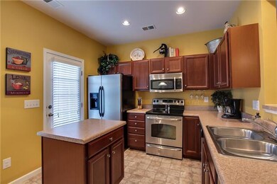 Kitcehn with stainless appliances, dark cherry cabinets and microwave built in. 