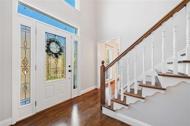 Entryway featuring stairs, a high ceiling, baseboa