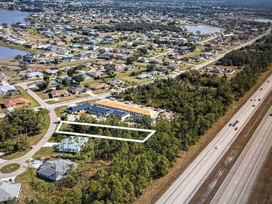 View of property location featuring a main thoroughfare, a large body of water, and nearby suburban area