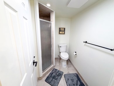 Bathroom with a shower stall and light tile patterned floors