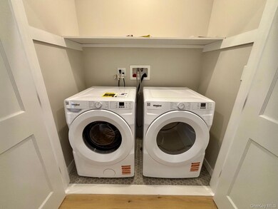 Laundry room featuring light wood-type flooring and washing machine and dryer
