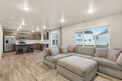 Living area with light wood finished floors and recessed lighting