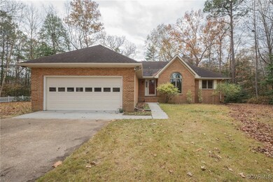 Single story home with a garage and a front lawn