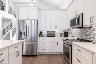 Kitchen featuring stainless steel appliances, light wood-style flooring, light countertops, tasteful backsplash, and white cabinets