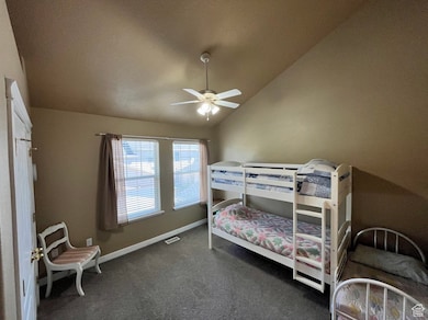 Bedroom featuring vaulted ceiling, carpet floors, and a ceiling fan